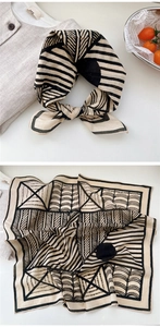 Detail of a square cotton scarf with black and white abstract geometric pattern