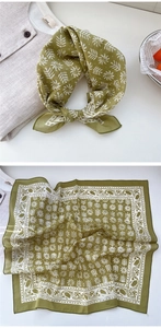 Detail of vintage green cotton scarf with white leaf prints and hemmed edge craftsmanship