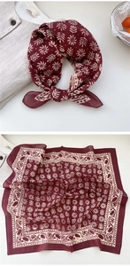 Detail of burgundy cotton square scarf with ethnic white patterns tied in a bow