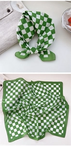Detail of green and white checkerboard cotton scarf with hemmed edges and texture