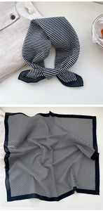 Detail of square black and white striped scarf with fine stitched edges and soft drape