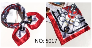 Detailed macro view of a square satin scarf with classic red white and black chain patterns