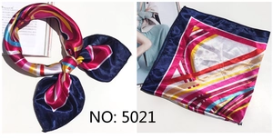 Detail of silk-feel square scarf featuring vibrant geometric patterns and navy color-blocking