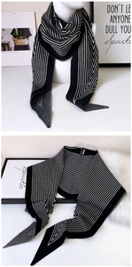 Detail of minimalist black and white striped knit scarf with chevron patterns