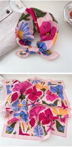 Detail of soft pink cotton scarf with colorful floral print and stylish knot display