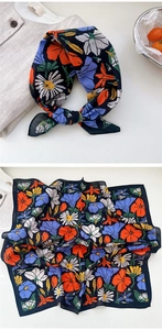 Close-up of vintage navy cotton scarf with colorful floral daisy pattern and necktie style