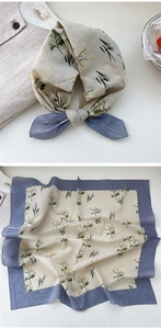 Close-up of square cotton scarf featuring vintage floral prints and soft blue borders