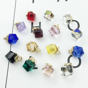 Macro view of colorful cube crystal pendants with gold alloy loops for DIY jewelry making