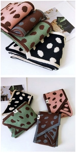 Dettaglio di sciarpe invernali in maglia con motivo a pois in quattro colori assortiti
