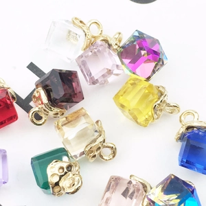Macro shot of colorful cube crystal pendants with gold alloy caps for DIY jewelry crafting