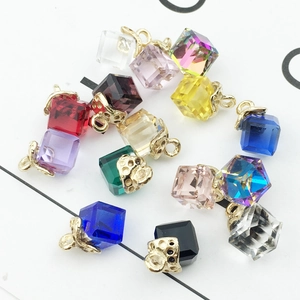 Detailed macro view of colorful cubic crystal pendants with golden hollow metal caps