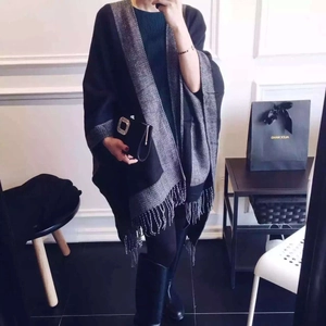 Détail du châle en tricot noir et gris avec motif à chevrons et longues franges