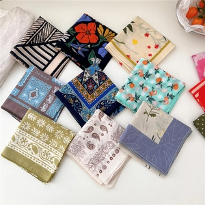 Assorted vintage floral and geometric pattern cotton square scarves on white surface