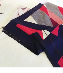 Macro detail of geometric color block scarf with soft knit texture and fringe edge