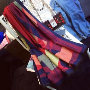 Close-up of geometric knit scarf with fringe trim detail and colorful diamond patterns