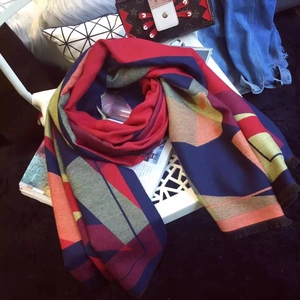 Close-up of geometric color block pattern and fine tassel fringe on soft cashmere scarf