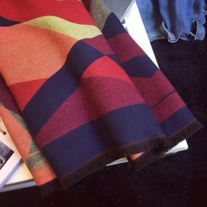 Close-up of thick geometric knit shawl with colorful blocks and soft fringe detail