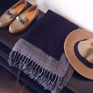 Écharpe style cachemire avec mocassins et chapeau sur table en bois foncé