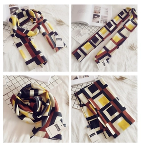 Detail view of long rectangular silk scarf with geometric color block patterns and smooth texture