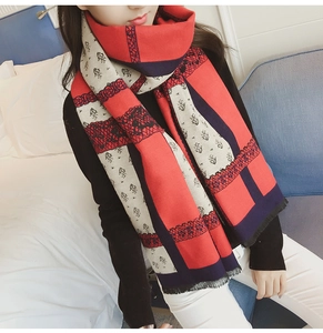 Detail of winter scarf featuring retro lion emblem pattern and geometric lace edges