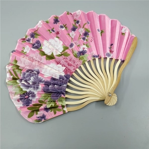 Detailed top view of a pink fabric fan with purple floral patterns and bamboo ribs