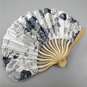 Detail showing grey and black floral fabric texture on a natural bamboo folding fan