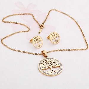 Golden Tree of Life jewelry set with sparkling rhinestones on a pale pink background