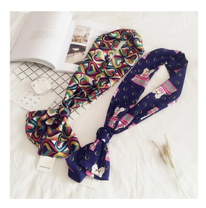 Detail view of two double-sided printed silk scarves with heart and swan patterns