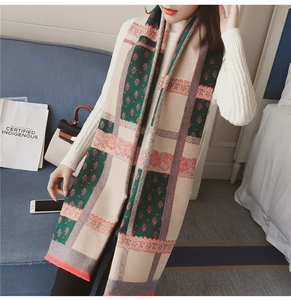 Detail of vintage cashmere-like scarf with floral patterns, plaid design and fringe trim