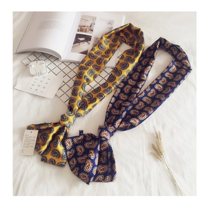 Detail of long satin neck scarves with vintage paisley pattern and luxurious glossy finish