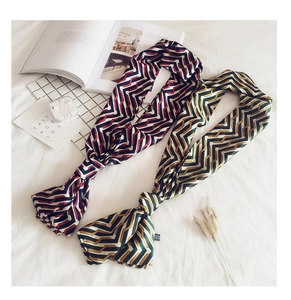 Detail view of colorful herringbone pattern long silk scarves with elegant satin texture