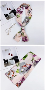 Detail of elegant floral satin scarf with smooth texture and soft pink flower patterns