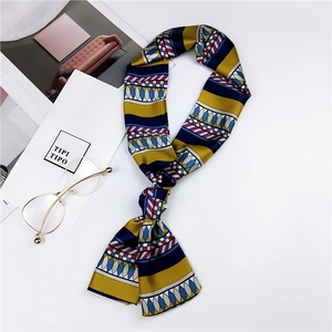Close-up of geometric silk twilly scarf with accessories in a lifestyle setup