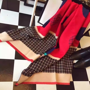 Detailed view of bicolor houndstooth pattern and soft frayed edges of the thick scarf
