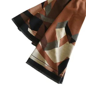 Thick geometric color-block scarf with fringe trim in caramel, coffee, and black tones