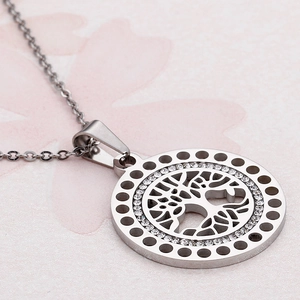 Silver tree of life pendant necklace with rhinestones on a soft pink background