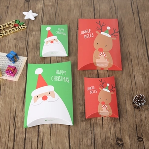Christmas pillow gift boxes with Santa and Reindeer patterns on a wooden surface