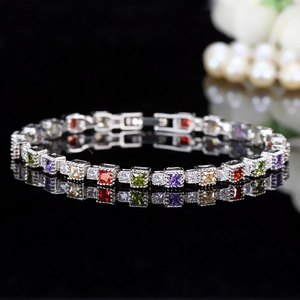 Macro detail of silver bracelet with multi-colored square crystals and secure claw setting