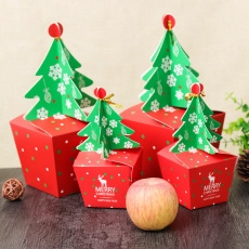 Detail of Christmas gift boxes with reindeer patterns and apple for size reference
