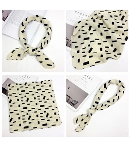 Detail of square scarf with geometric print and decorative leather diamond buckle