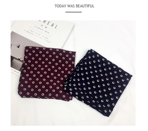Close-up of navy and red polka dot cotton linen scarves with stylish diamond leather buckle