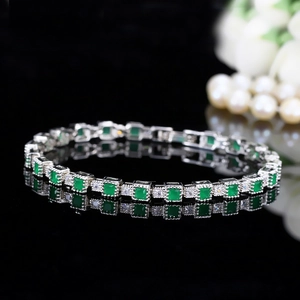 Detail of silver bracelet featuring square emerald green stones and round zircons