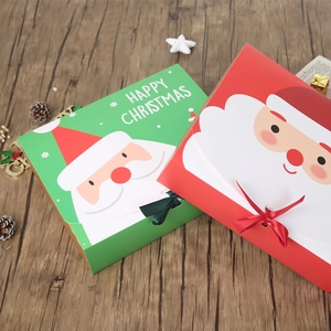 Festive red and green Christmas gift boxes with gold foil Santa and ribbon on wood
