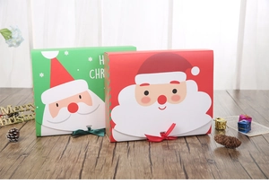 Detailed view of red and green Santa Claus gift boxes with ribbons on a wooden desk