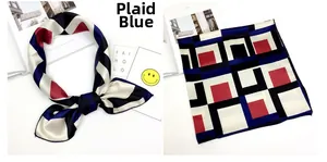 Dettaglio di un foulard di raso con motivi geometrici blu navy e rosso piegato