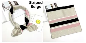 Dettaglio di un foulard quadrato in seta beige a righe con pois e cuciture sui bordi