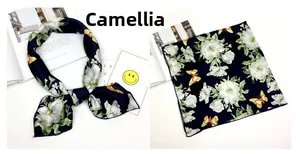 Dettaglio di foulard di seta blu navy con motivi di camelia bianca e farfalle