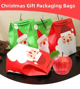 Detail view of red and green Christmas paper gift bags with Santa Claus illustrations