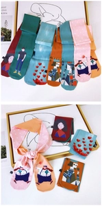 Detail view of colorful patterned silk scarves with cartoon characters and artistic prints