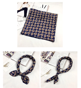 Dettaglio di un foulard di seta blu navy con motivo paisley e trama liscia satinata